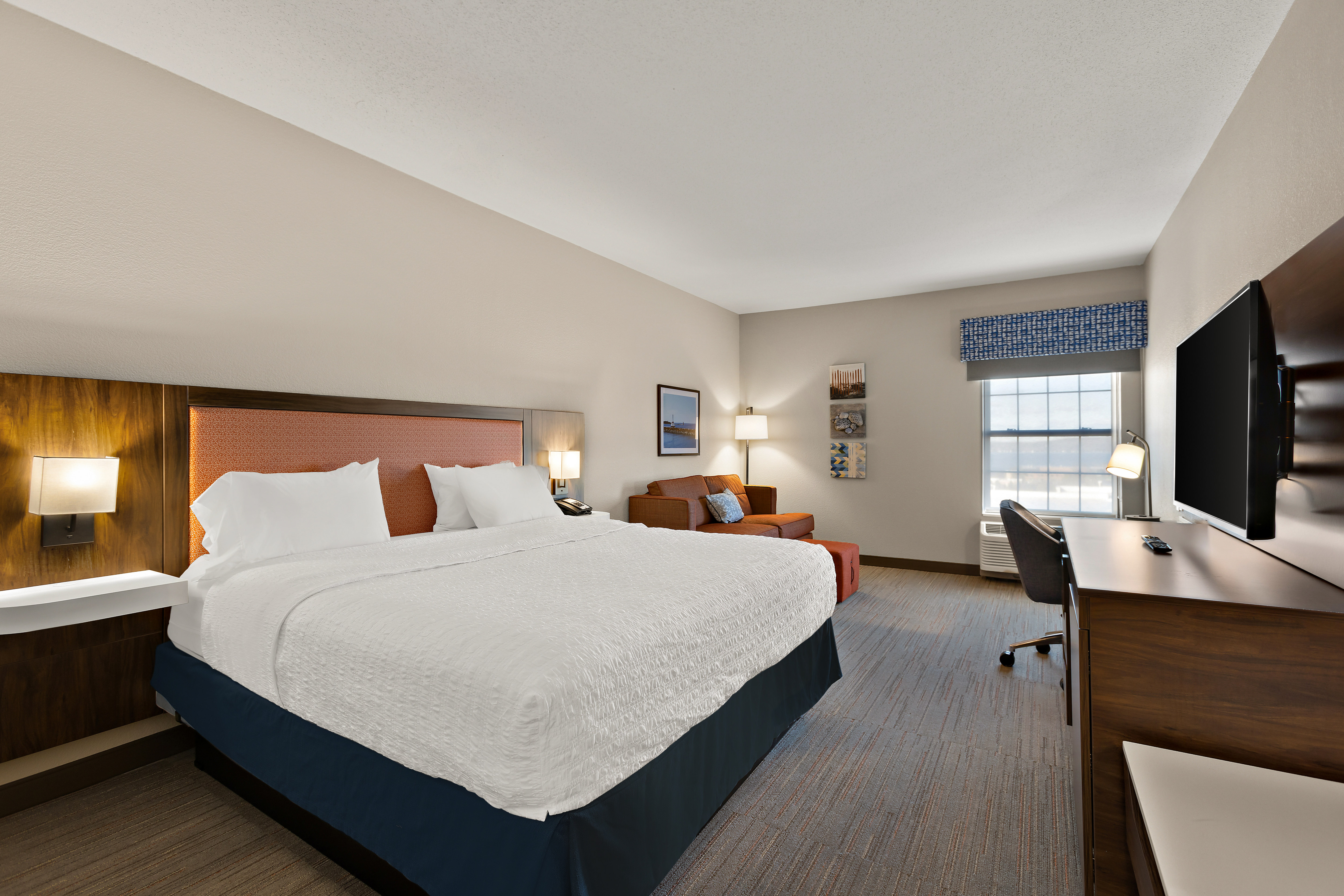 Guest bed on left with lounge area in back and tv area on right