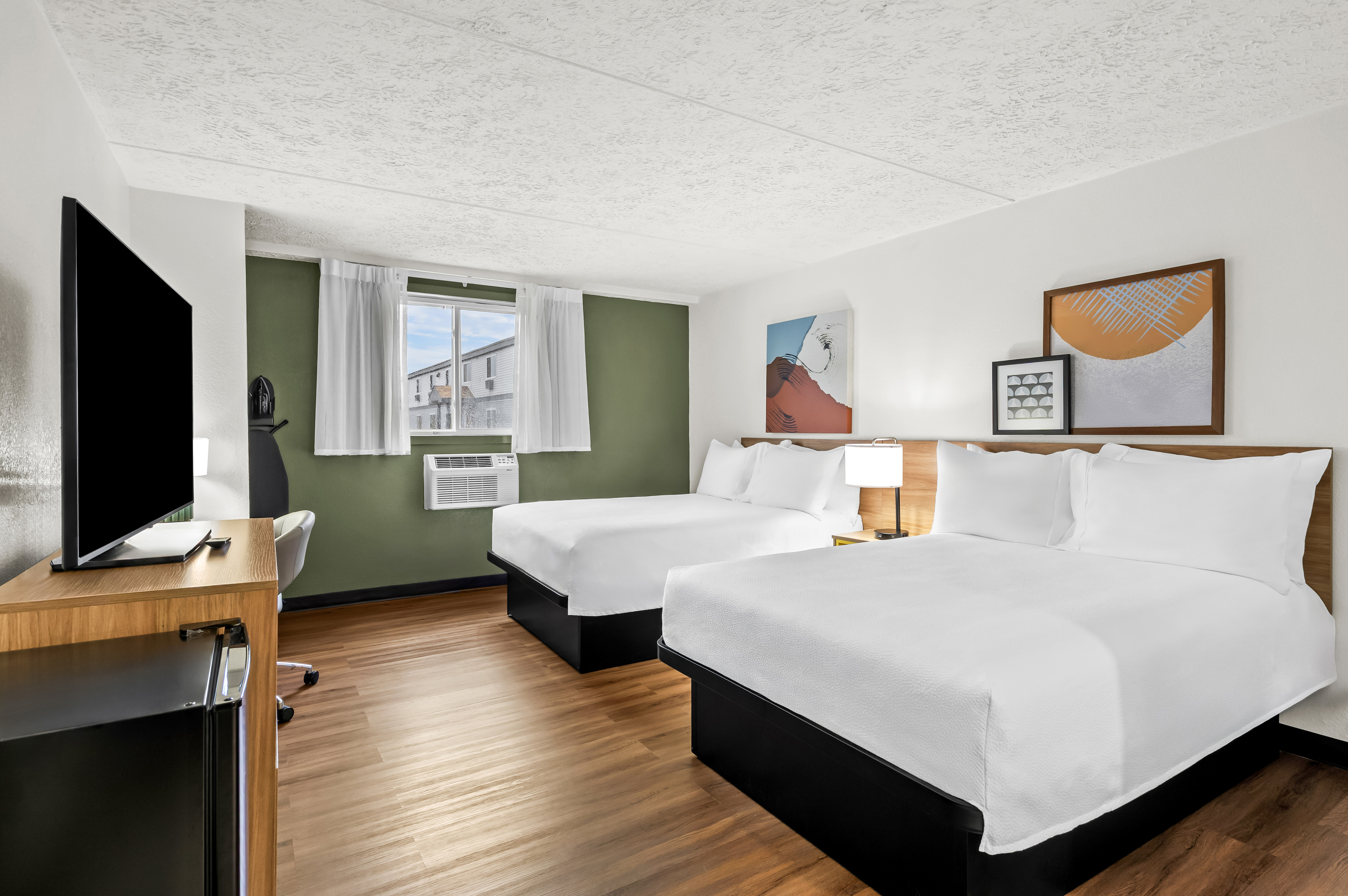 guestroom with two double beds and tv