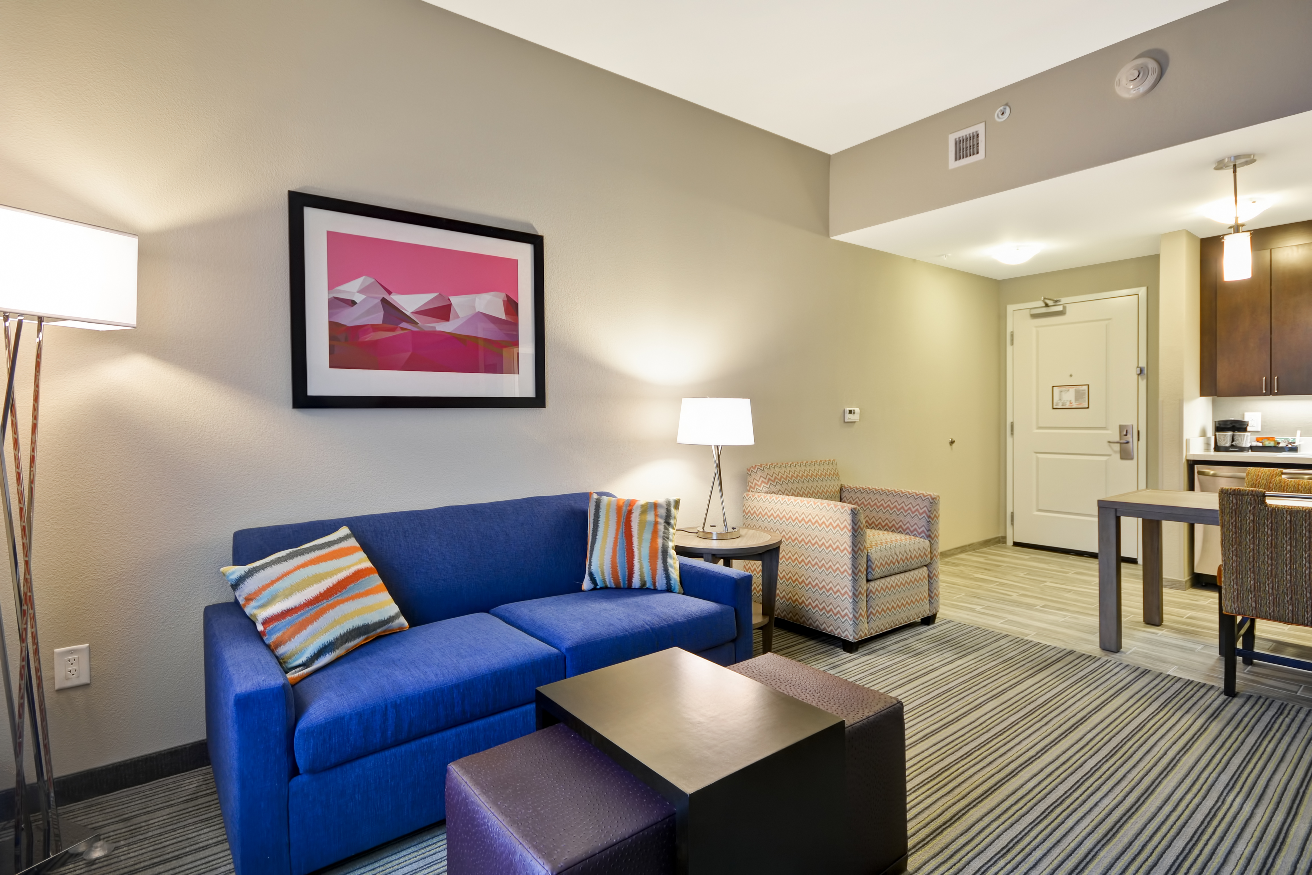 Illuminated LAmps, Wall Art Above Sofa, Armchair, Entry, Kitchen, and Dining Table in Suite