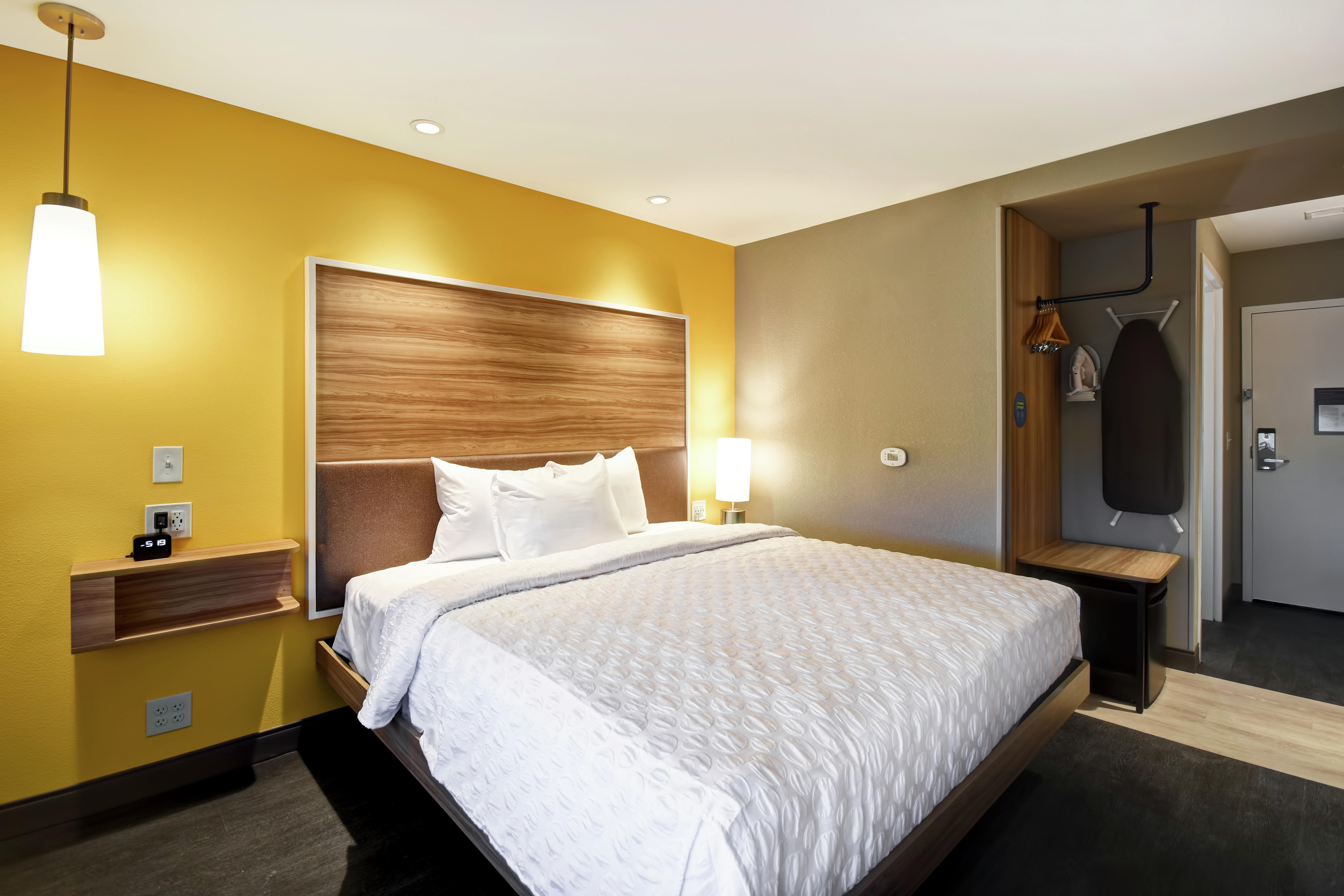 One King Bed Guest Bedroom with Wall Mounted Iron Board