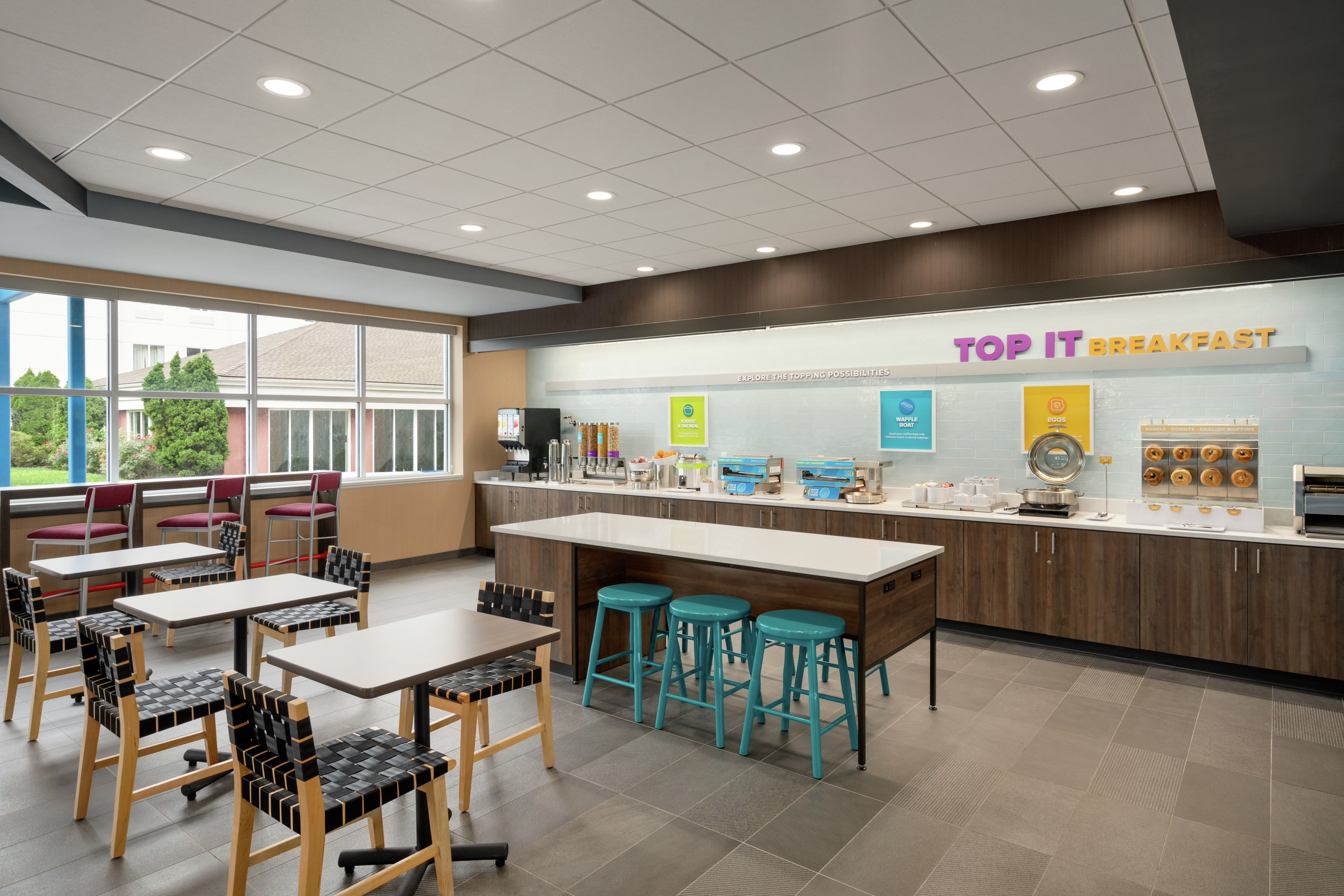 Bright breakfast serving area featuring ample seating and complimentary buffet.