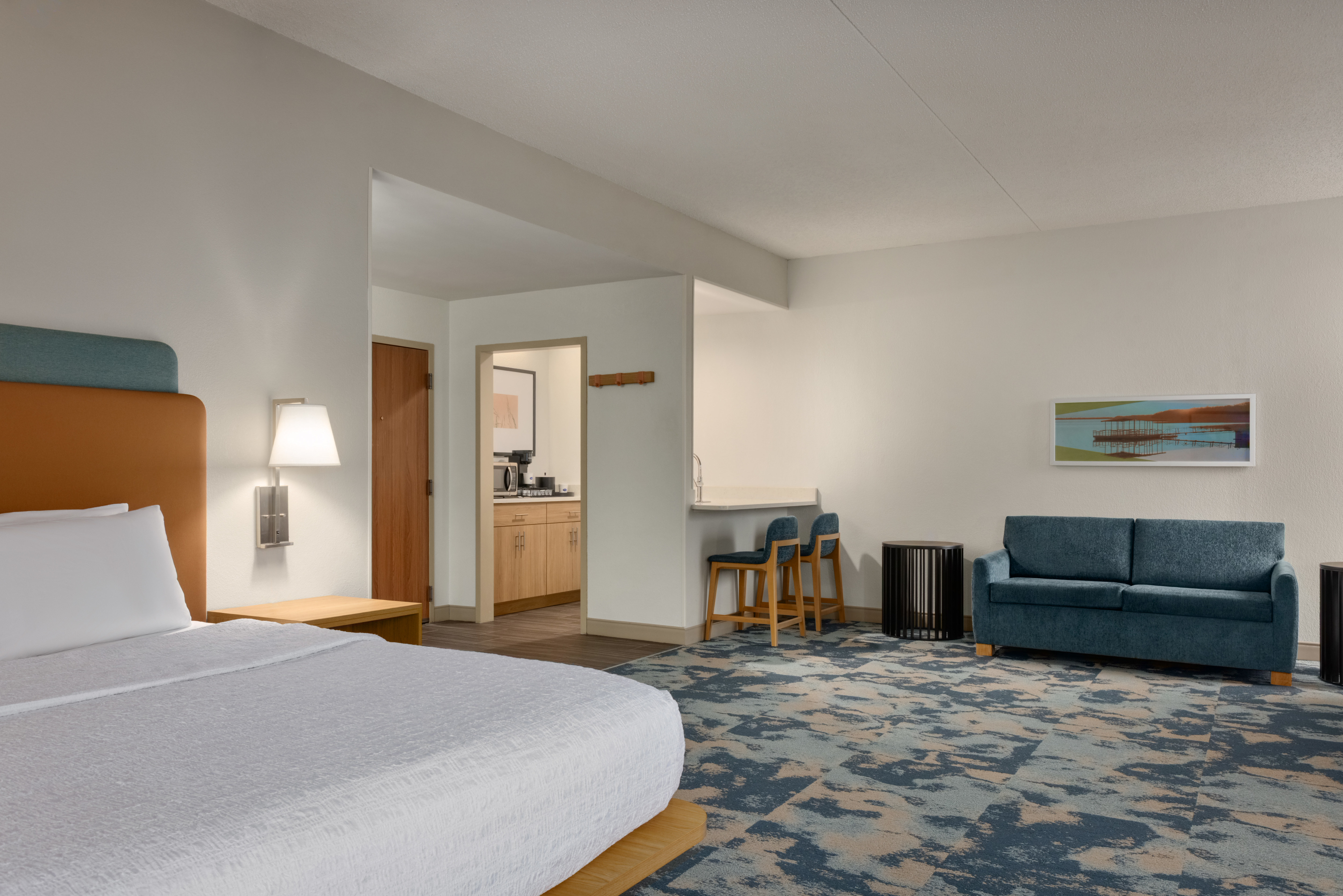 Suite with a king bed, cozy couch and wet bar