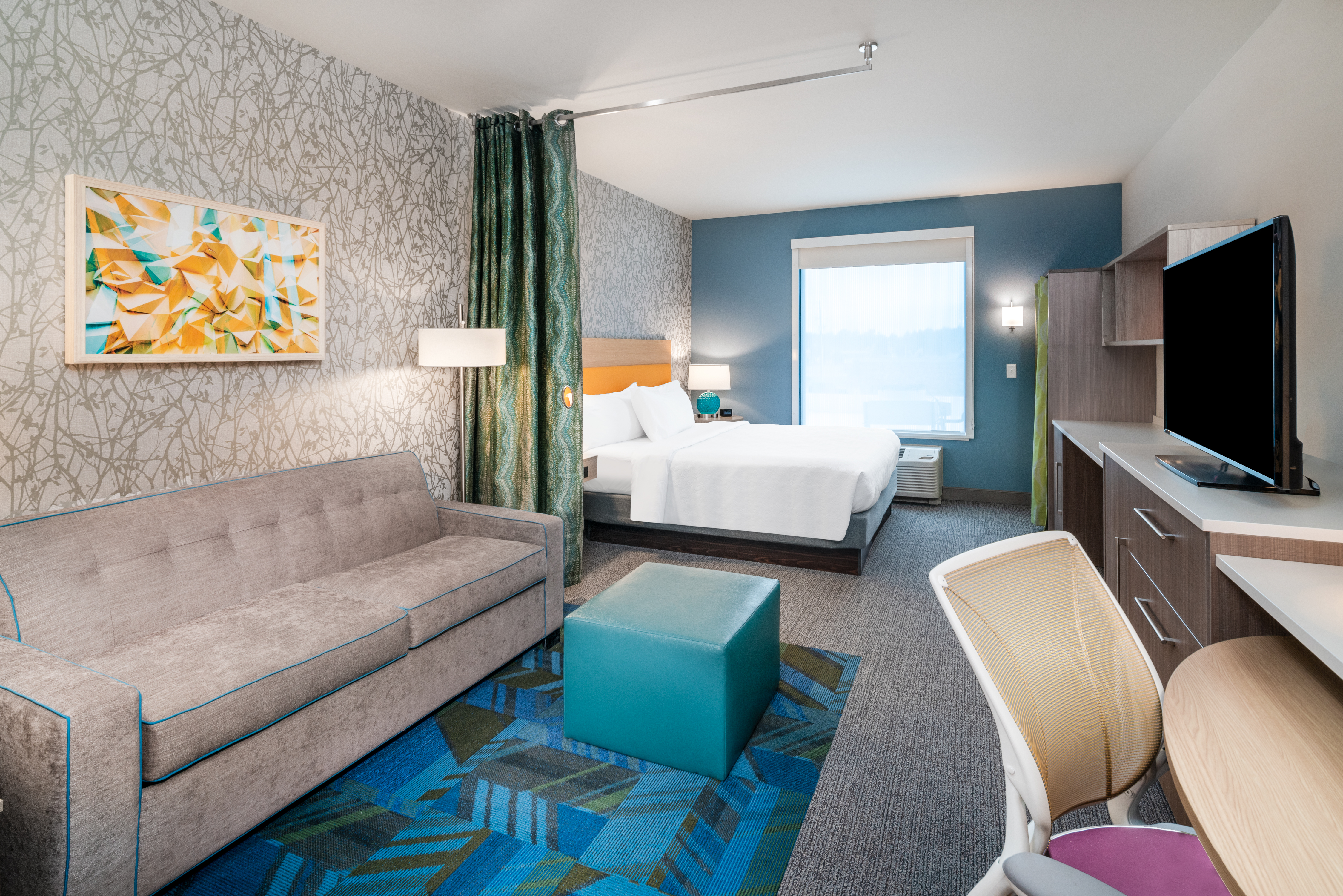 Desk HDTV Sofa and Large Bed in Hotel Guest Room