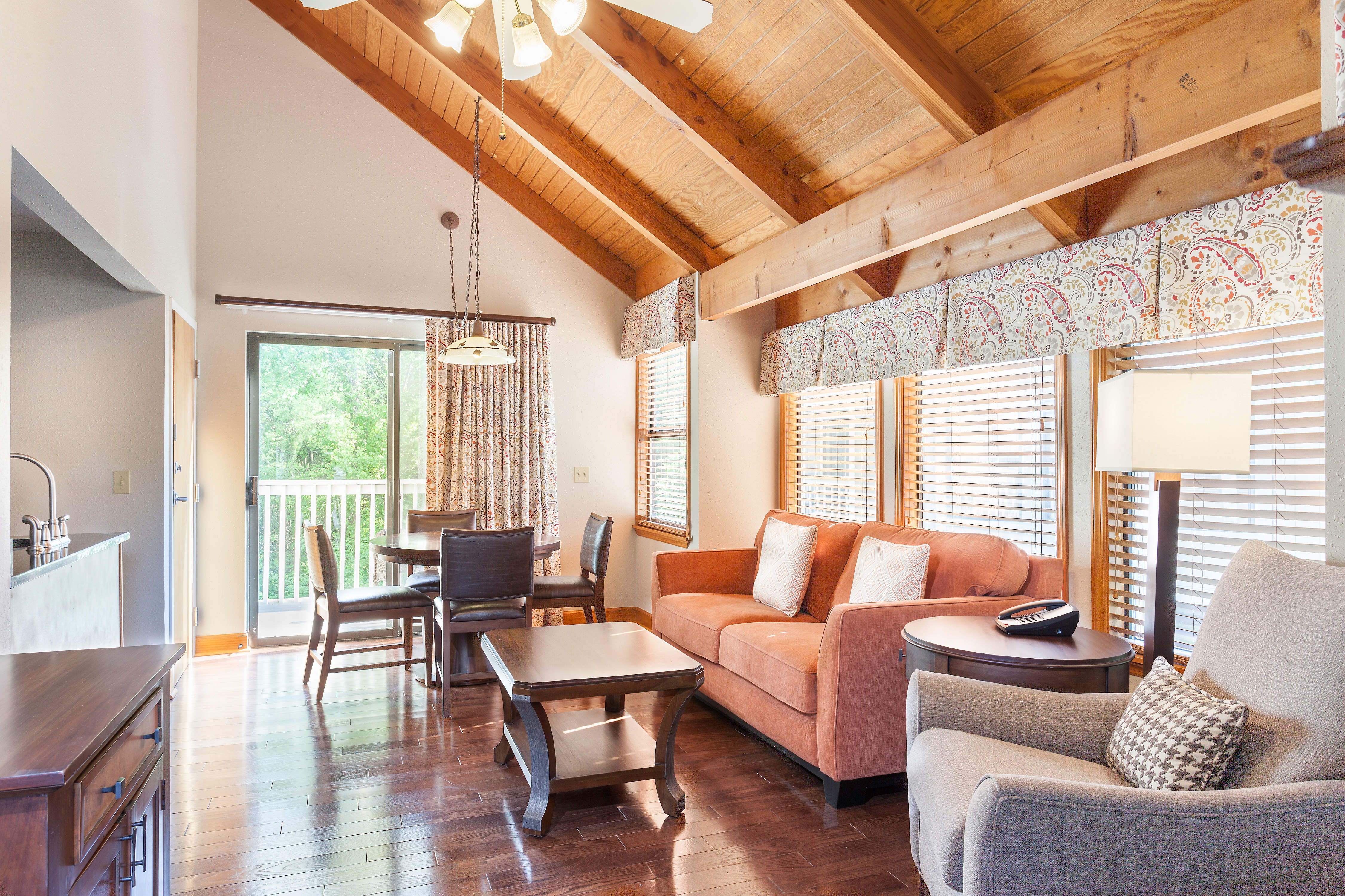 Living and dining room with armchair, sofa, and dining table and chairs for four people