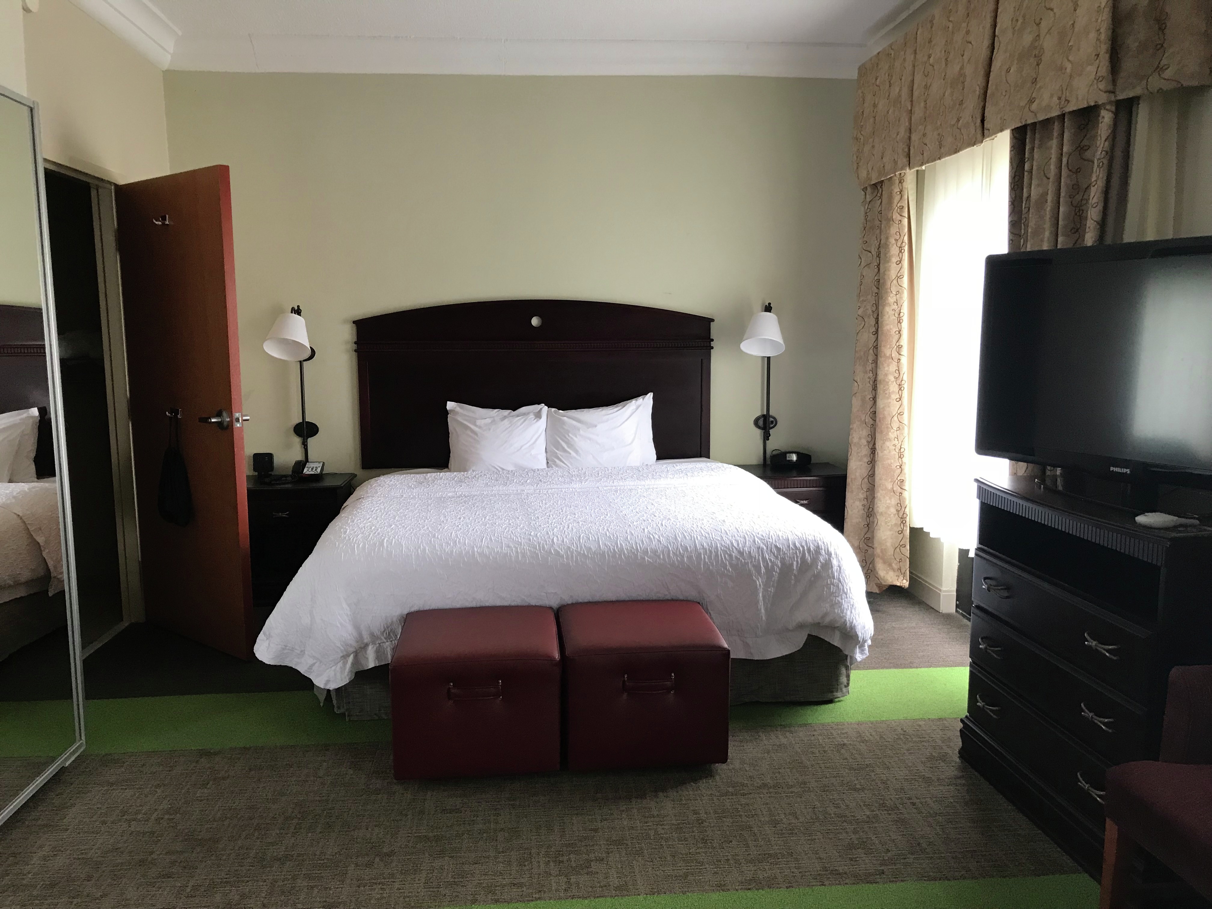 Guest room with bed, TV and window.